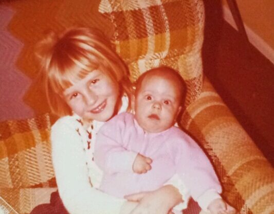 Heidi Winkler as a child holding her baby sister